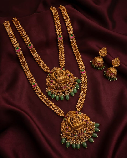 Gold necklace with green beads and matching earrings on a dark fabric background