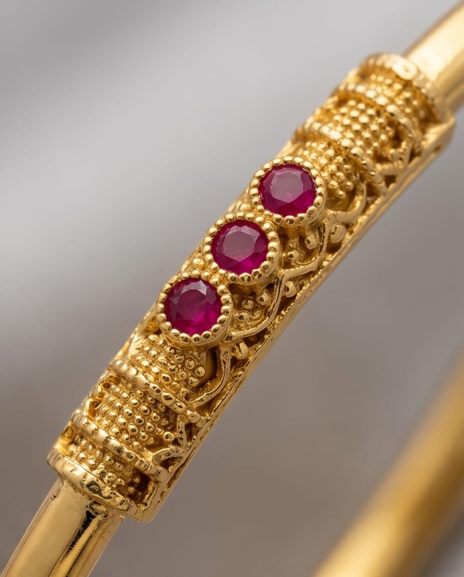 Gold pen with red gemstones on a gray background