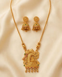 Gold necklace with intricate design and matching earrings on a beige fabric background