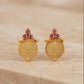 Gold earrings with gemstones on a beige background