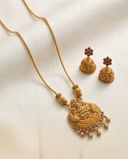 Gold necklace with matching earrings on a light beige background