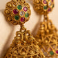 Gold earrings with gemstones on a beige background