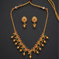 Gold necklace and earrings set on a dark background