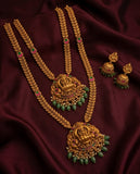 Gold necklace with green beads and matching earrings on a dark fabric background