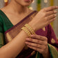 Woman wearing gold jewelry with a blurred background