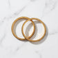 Two gold bangles on a marble surface