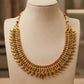 Gold necklace with gemstones on a mannequin bust