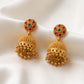Gold earrings with gemstones on a white fabric background