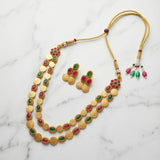 Gold necklace with colorful gemstones on a marble background