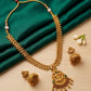 Gold necklace with intricate design on a green fabric background