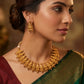 Woman wearing gold jewelry with a blurred background