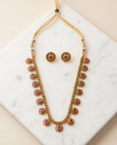 Gold necklace with pink stones on a marble surface