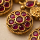 Gold and red gemstone jewelry on a beige background