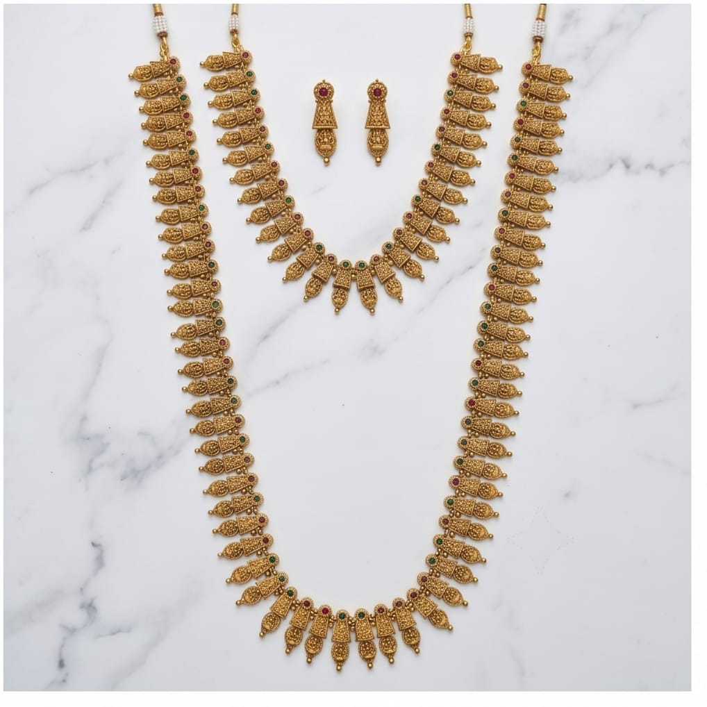 Gold necklace and earrings set on a marble surface